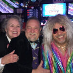 Three friends in festive attire smiling for the camera.