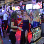 People dancing in a lively nightclub with colorful lights.